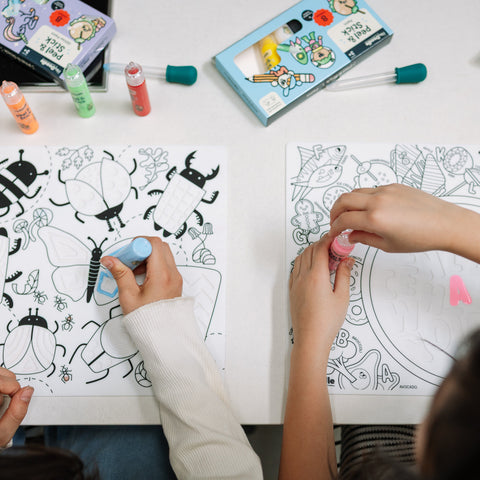 two girls coloring on sensory mat using peel and stick paints